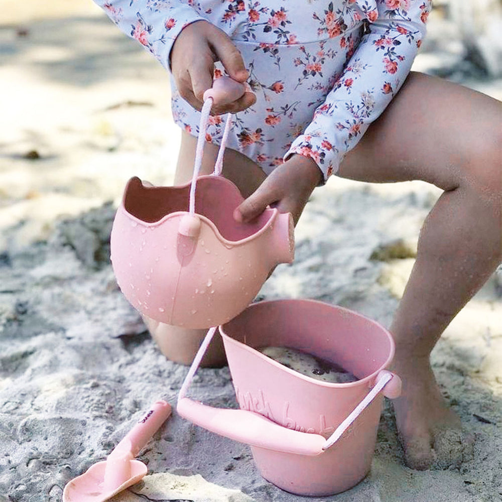 Heerlijk spelen met deze strandset in kleur oud roze van Scrunch. De set bestaat uit een emmer, 4 vormpjes en een schepje. De emmer en vormpjes zijn gemaakt van flexibele silicone, de schep van kunststof. VanZus