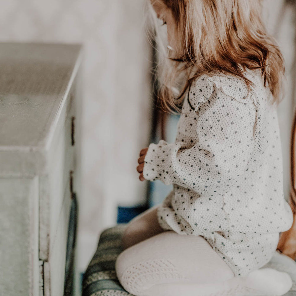 Voeg een klassieke look toe in de garderobe van je baby met het schattige rompertje Isabella in lots of love sky. Lange mouwen, witte kleur met stippen en hartjes, kant en ruches! In diverse maten. VanZus