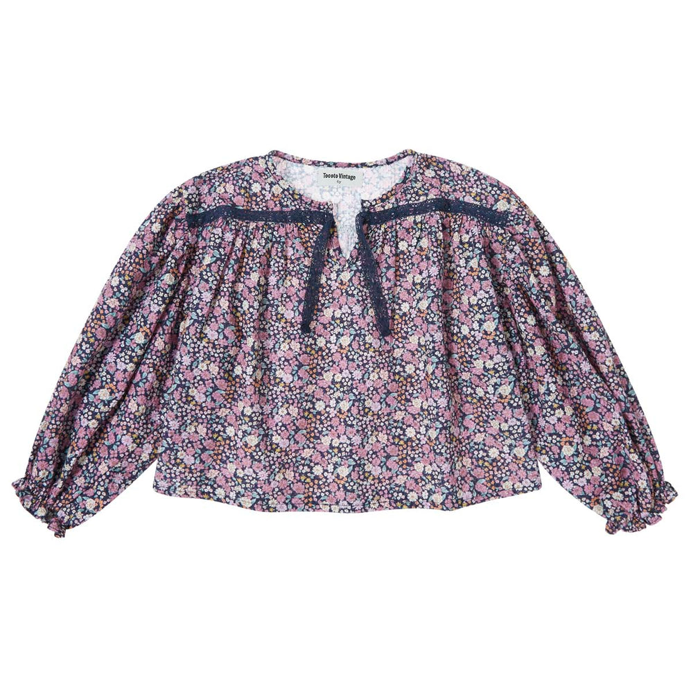 De lace blouse flowers navy van het merk Tocoto Vintage is zacht, comfortabel en heeft een klassieke uitstraling. Met klassieke bloemenprint, ruches en kant. In maten 98 t/m 140. VanZus