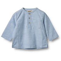 Het Wheat bjørk shirt in de kleur blue stripe is een super leuke blouse voor jouw baby. De blouse heeft een mooie blauwe kleur met witte streepjes, een ronde hals en een leuk zakje op de borst. VanZus.
