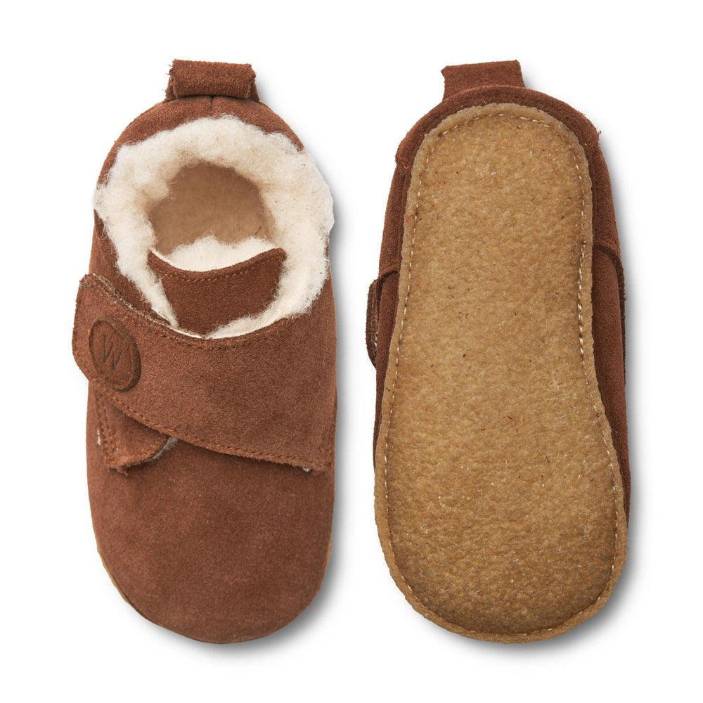 Houd de voetjes van je kleintje warm met deze heerlijke warme en knusse pantoffels met klittenbandsluiting en wollen voering. De Wheat taj sloffen in de kleur cognac zijn zacht, warm en cosy. De pantoffels zijn flexibel, waardoor ook de kleinsten er goed mee kunnen bewegen. VanZus