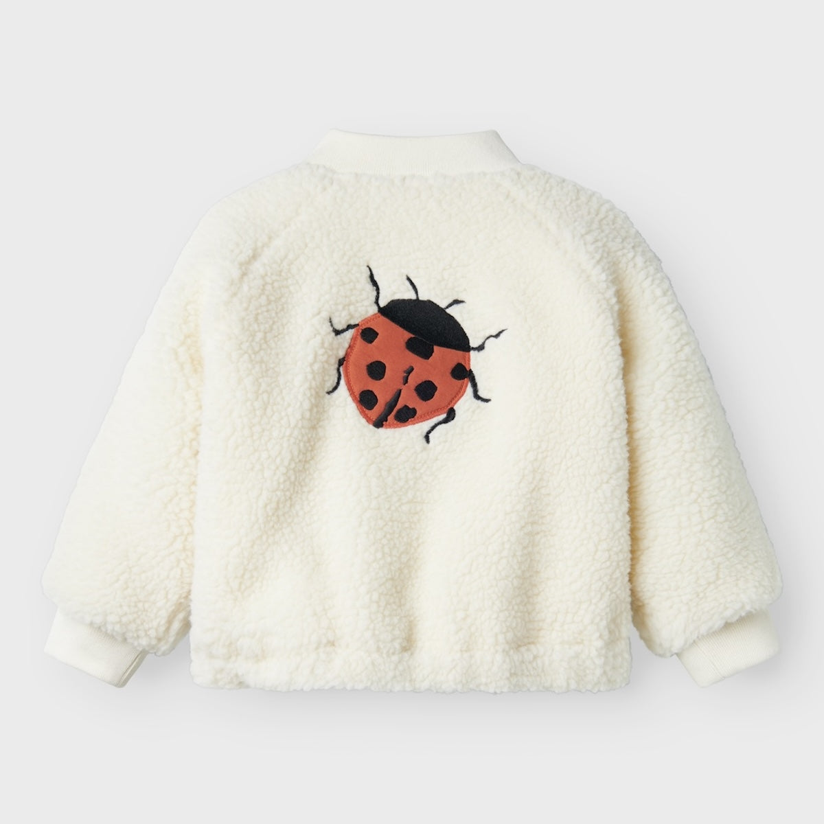 Bomberjack mini ladybug in de kleur coconut milk van Lil'Atelier. Gebruik hem als vest, tussenjas of zomerjas. Zachte stof, handige zakjes, ritssluiting en elastische boorden. In verschillende maten. VanZus