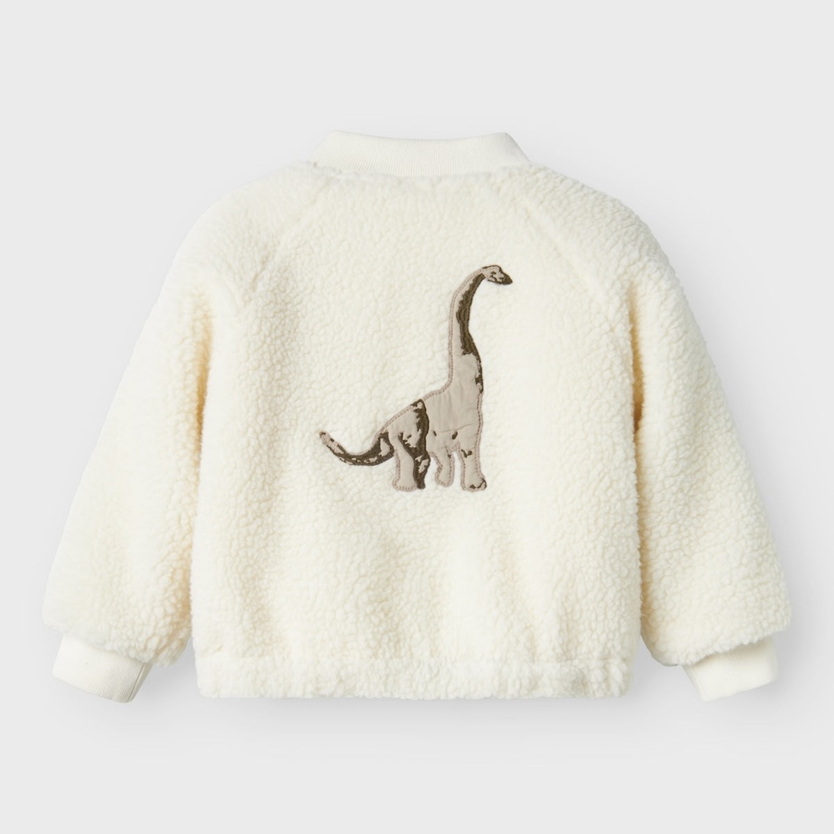 Een zacht, hip en praktisch jasje: de mini dino bomberjack in coconut milk van Lil' Atelier. Met een ritssluiting, handige zakjes en een stoere dino print. In verschillende maten. VanZus