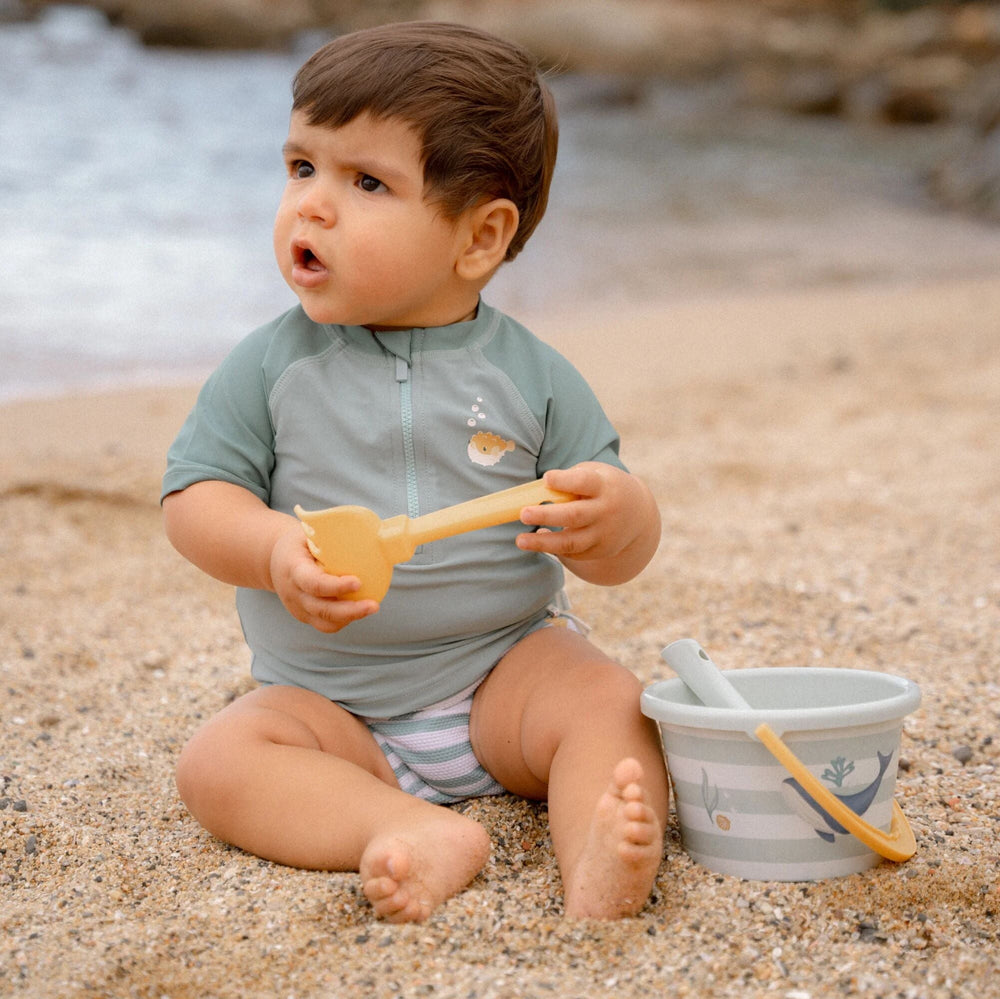 Ben jij klaar voor een dagje waterpret? Dit zwemshirt in de seashells surf blue van Little Dutch met korte mouwen van gerecycled polyester houdt je warm in het water en beschermt je tegen de zon terwijl je de hele dag speelt. VanZus