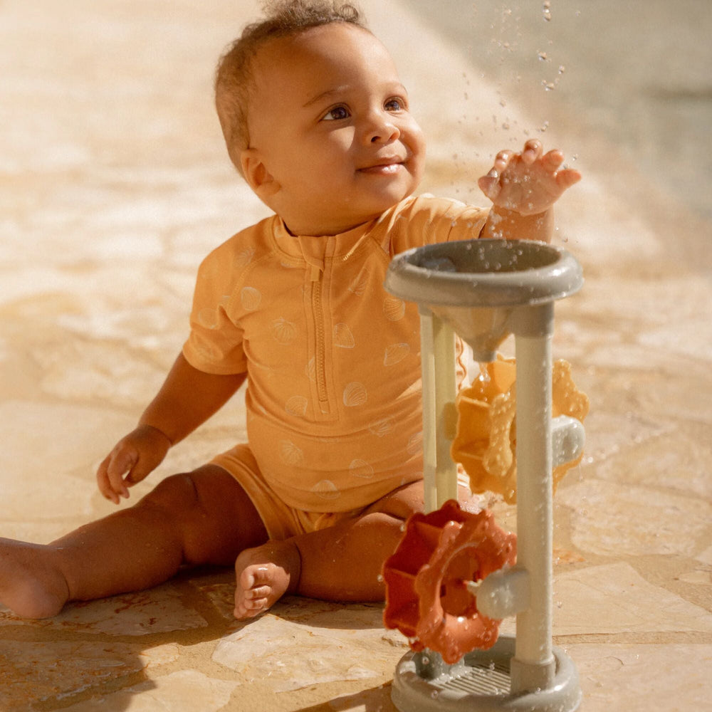 Ben jij klaar voor een dagje waterpret? Dit zwemshirt in de seashells sunny yellow van Little Dutch met korte mouwen van gerecycled polyester houdt je warm in het water en beschermt je tegen de zon terwijl je de hele dag speelt. VanZus