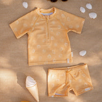 Je kindje is helemaal klaar voor het strand, het zwembad en voor zomerse vakanties met deze lieve zwembroek in de variant seashells sunny yellow van het merk Little Dutch. De zwembroek is voorzien van een elastische tailleband met trekkoord. VanZus