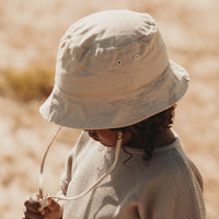 De Mrs. Ertha bucket hat in de kleur peanut is de ideale hoed voor de warme dagen. Het hoedje kan door middel van een koord strakker worden getrokken, waardoor de hoed niet van het hoofd af kan vallen.