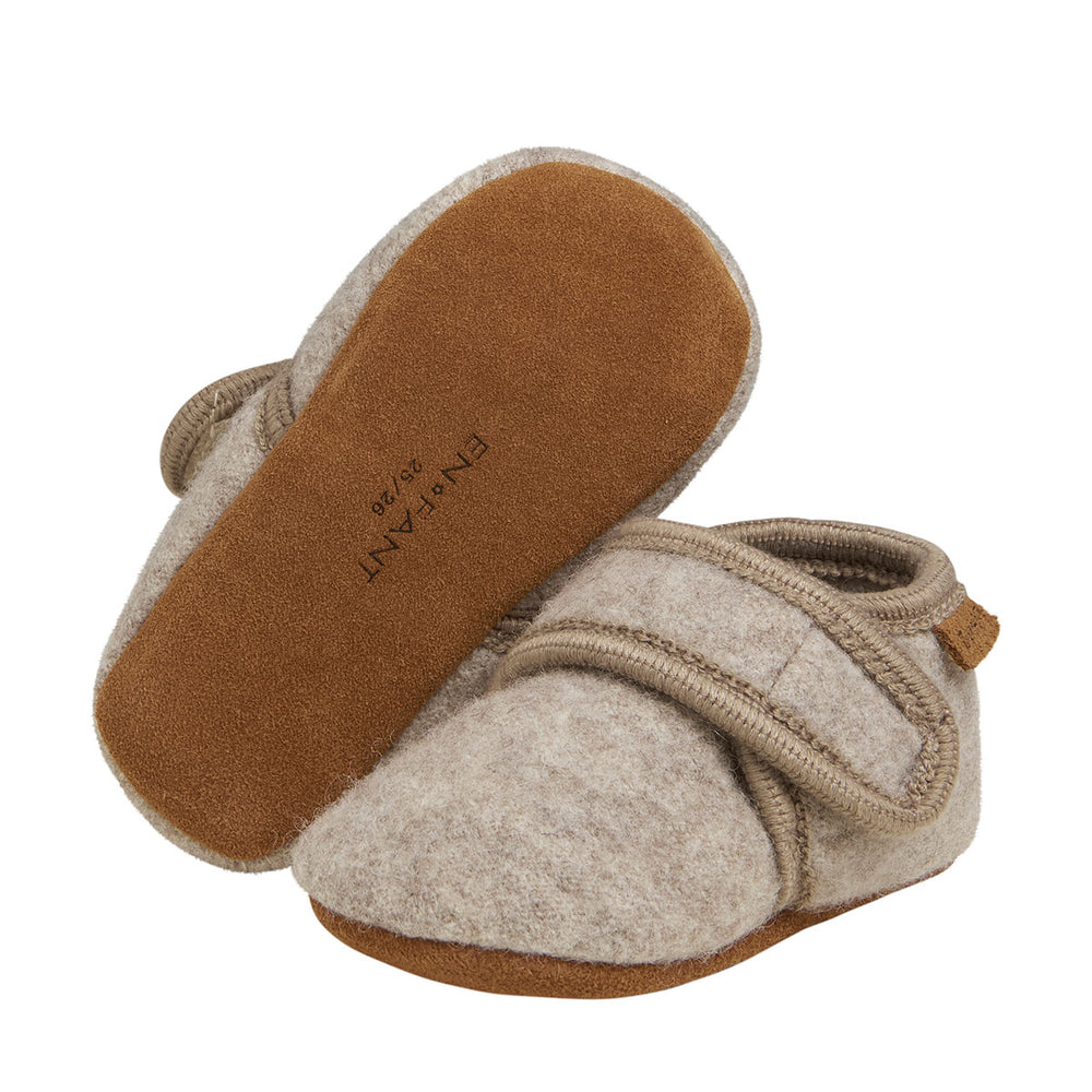 Dit zijn de En Fant wollen baby sloffen sand melange: een musthave voor je baby. De zandkleurige sloffen zijn heerlijk soepel en ademend en gemaakt van wol met een suède zool voor extra grip. VanZus.