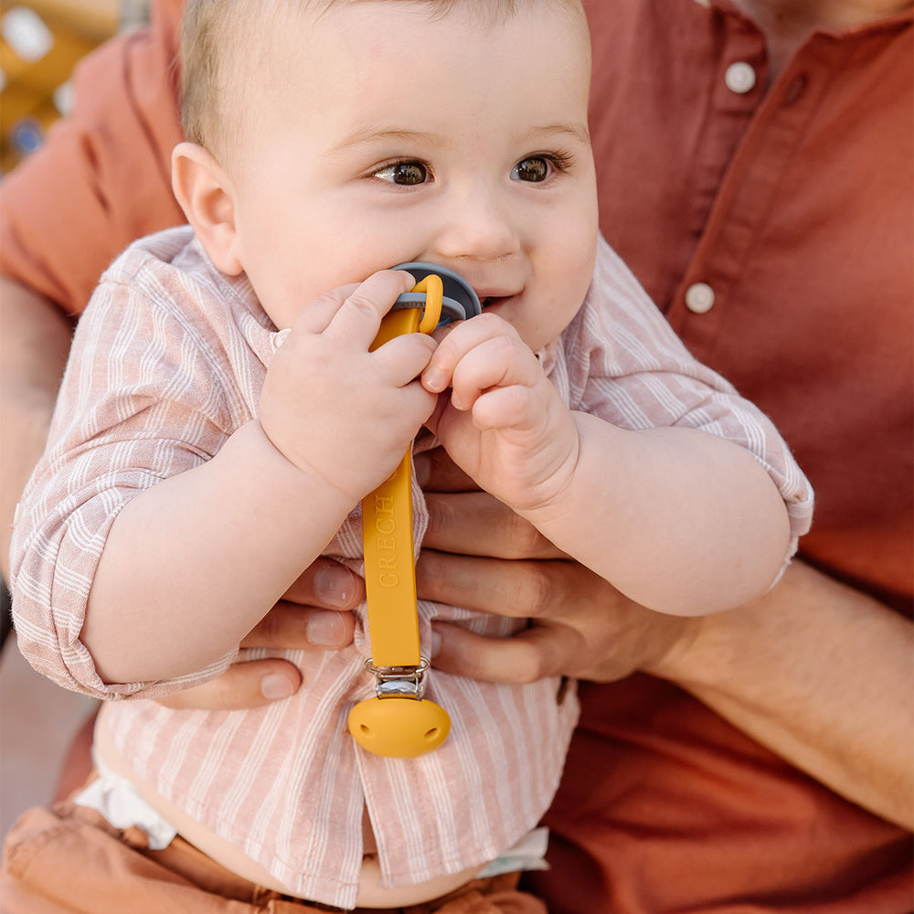 Het Grech & co. speenkoord siliconen in de kleur golden is een handig en stijlvol accessoire voor baby's, ontworpen om te voorkomen dat de fopspeen van je kleintje kwijtraakt of op de grond valt. VanZus