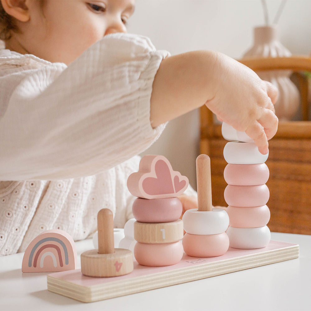 Deze Label Label stapelringen roze is een mooie, houten stapeltoren met staven, waarover je kind verschillende houten ringen en enkele vormpjes kan schuiven. Goed voor de ontwikkeling van de oog-hand-coördinatie. VanZus.