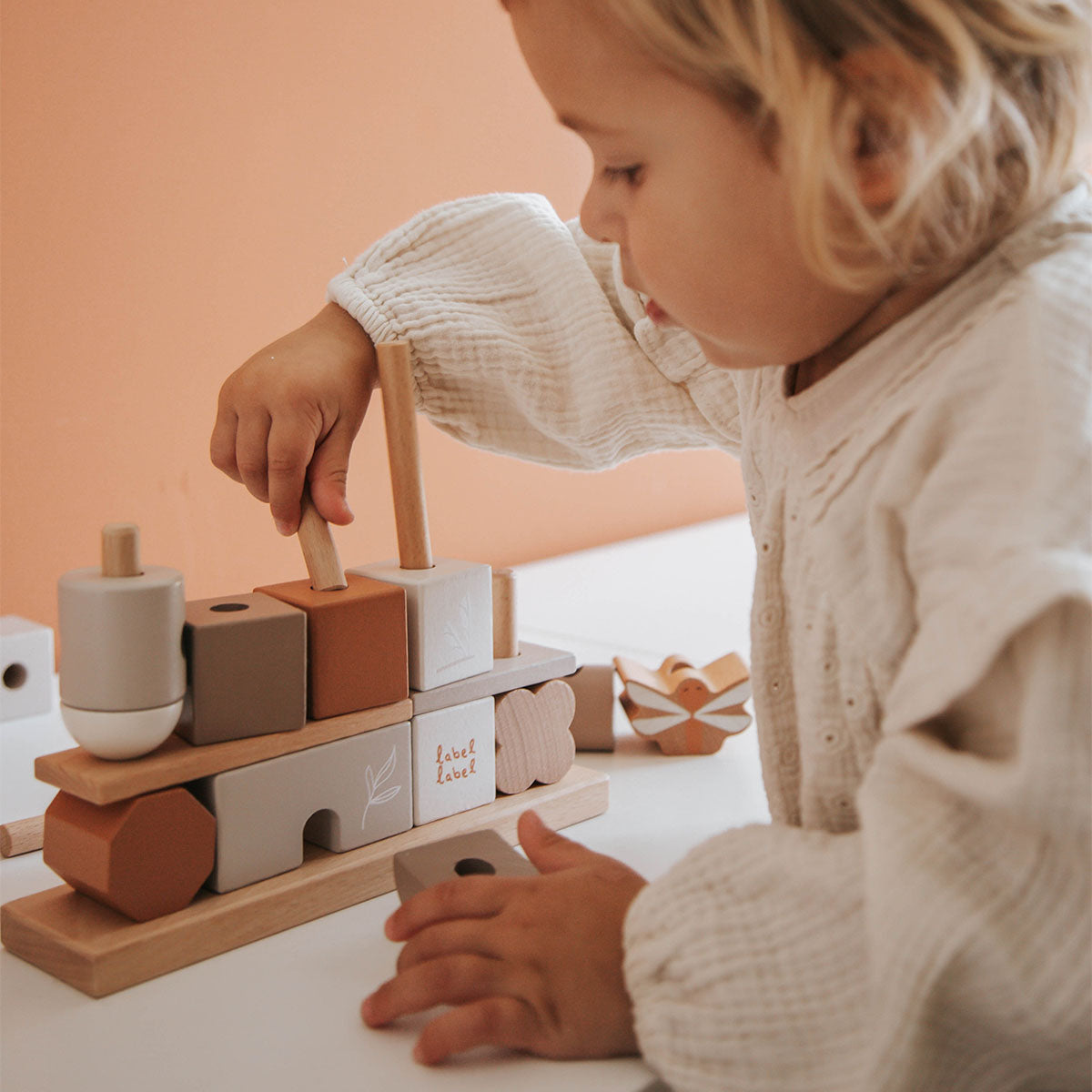 Deze Label Label stapelblokken huis nougat staat als een huis, want dit is geen bouwblokkenset, nee dit is een stapeltoren met staven, waarover je kindje de verschillende vormen en kleuren blokjes kan schuiven. VanZus.