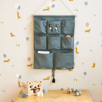 Extra opbergruimte aan het bed of de box voor het favoriete boekje of speen van jouw kindje. De wall organizer olifant met geborduurde dierenkop en oortjes van Roommate is decoratief én functioneel. VanZus